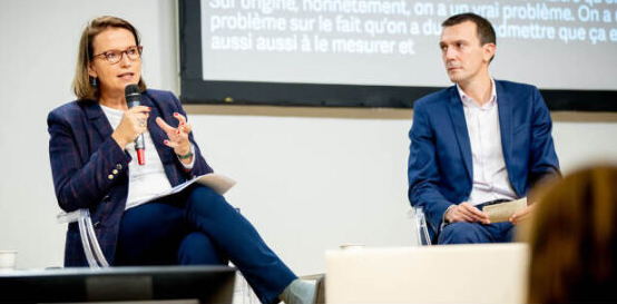 Photographie de Claire Hédon, Défenseure des droits, et Johan Titren, coprésident de l'AFMD, sur une scène de conférence. Claire Hédon tient le micro et prend la parole. Johan Titren la regarde parler.